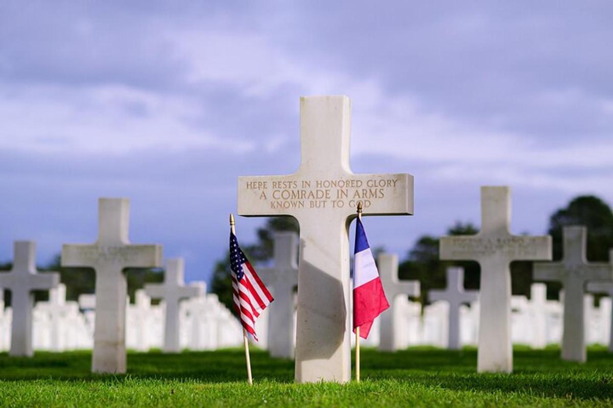 a cross with two flags in a cemetery