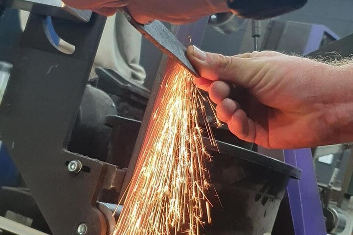 a person cutting a piece of metal on a machine