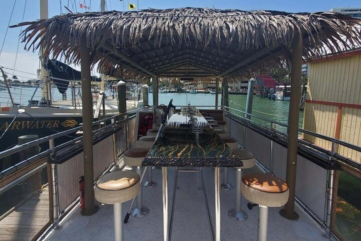 a table and chairs on a boat with a straw roof