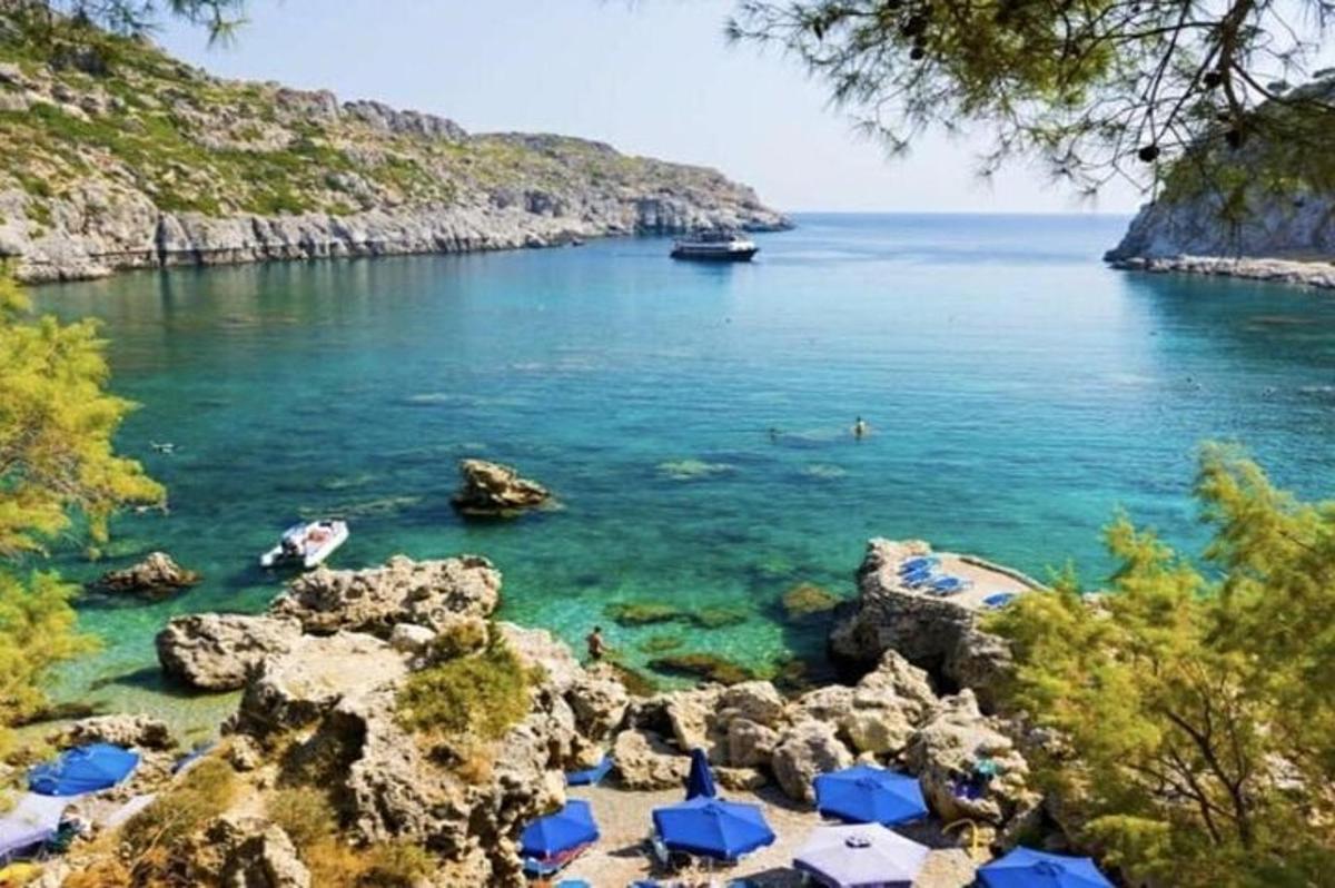 egy strand kék napernyőkkel és vízzel