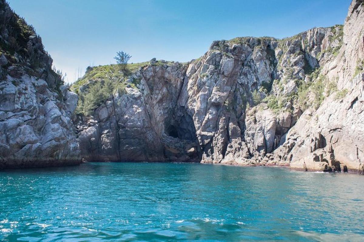 uno specchio d'acqua vicino a una scogliera rocciosa