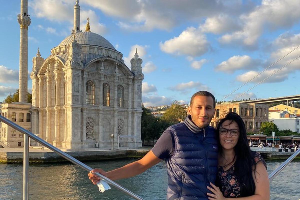 Un hombre y una mujer posando frente a un edificio.