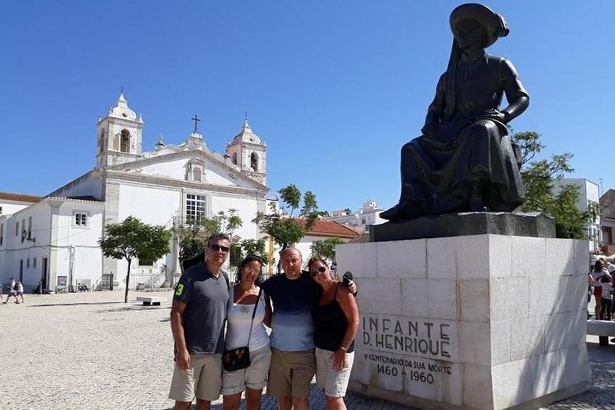 um grupo de pessoas em pé em frente a uma estátua