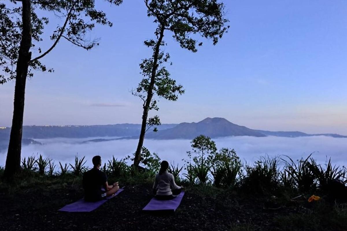 hai người ngồi trên chiếu trên một ngọn đồi có tầm nhìn