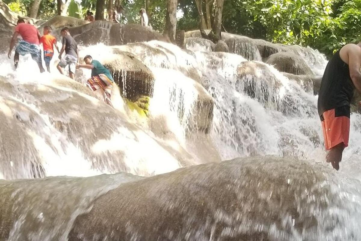 một nhóm người đang đứng trong thác nước