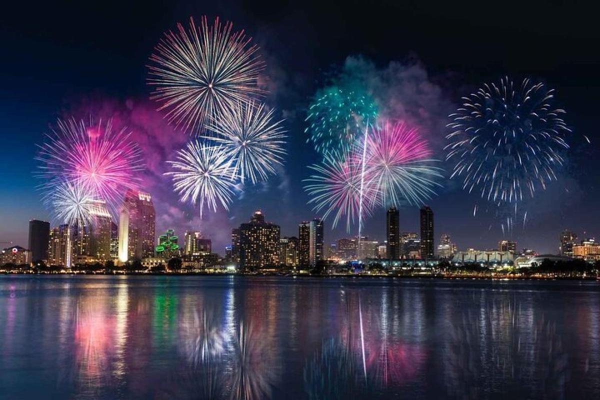 Un espectáculo de fuegos artificiales sobre el agua con una ciudad