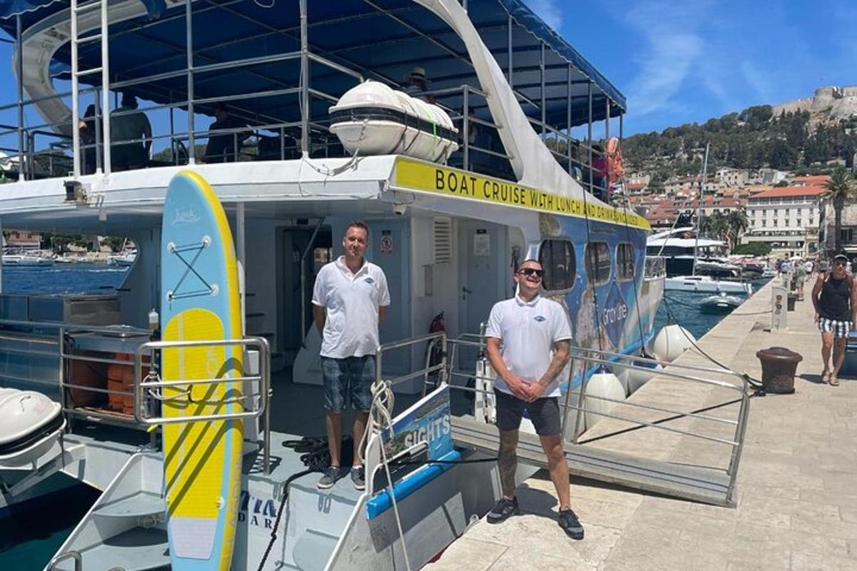 two men are standing on the front of a boat