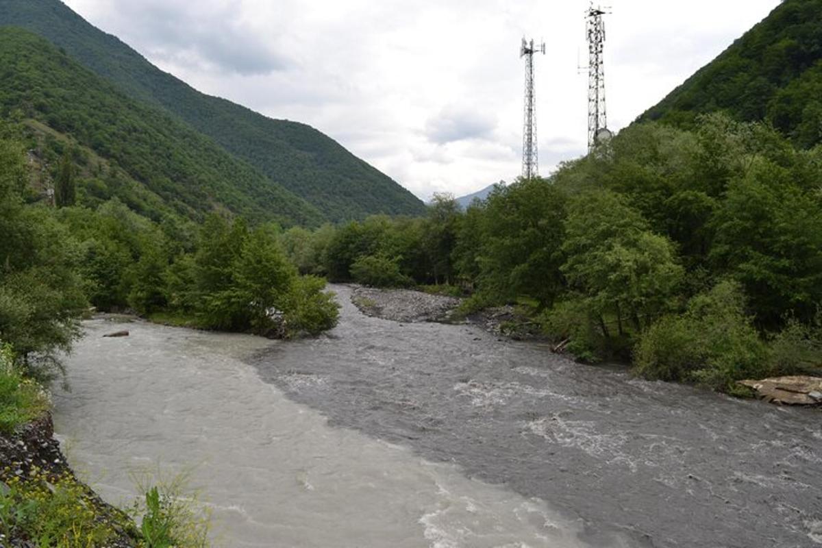 un río con árboles en la ladera de una montaña