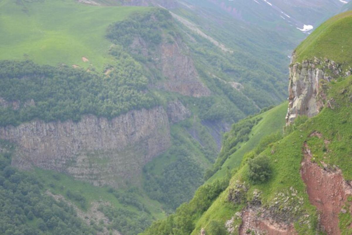 una vista di una montagna con colline verdi e alberi