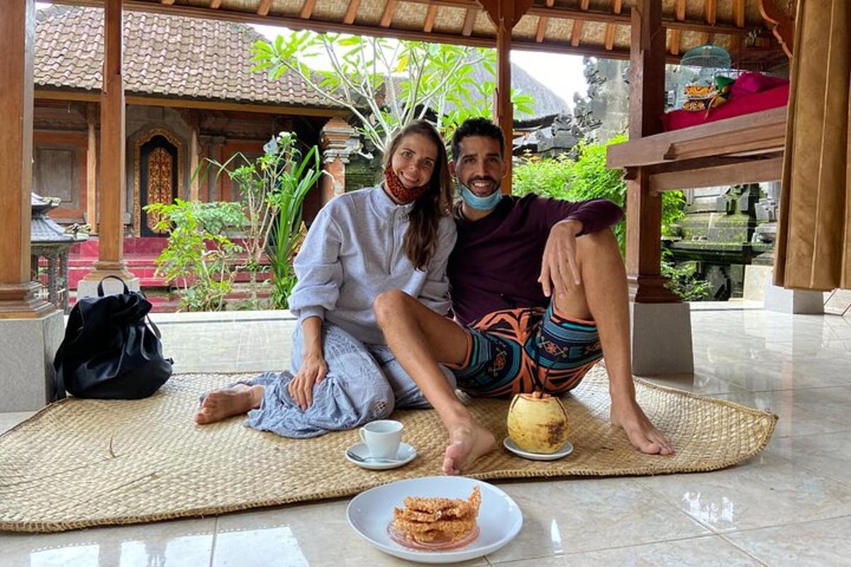 a man and a woman sitting on the floor with plates of food