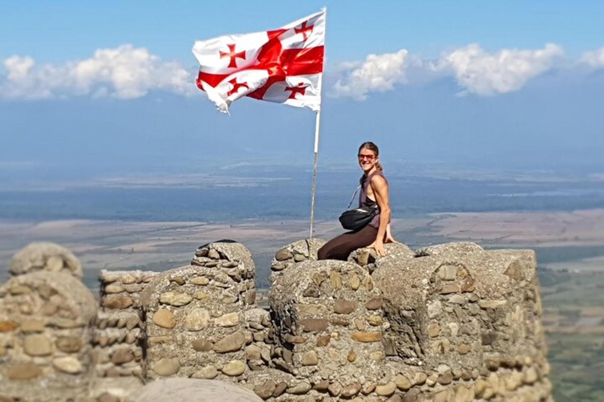 una donna seduta in cima a un castello con una bandiera