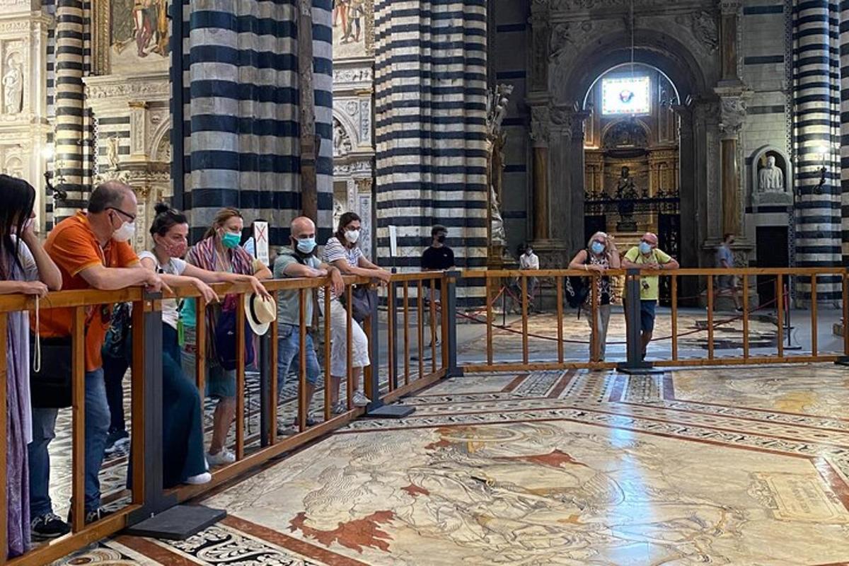 Un grupo de personas mirando por encima de una valla en una catedral.
