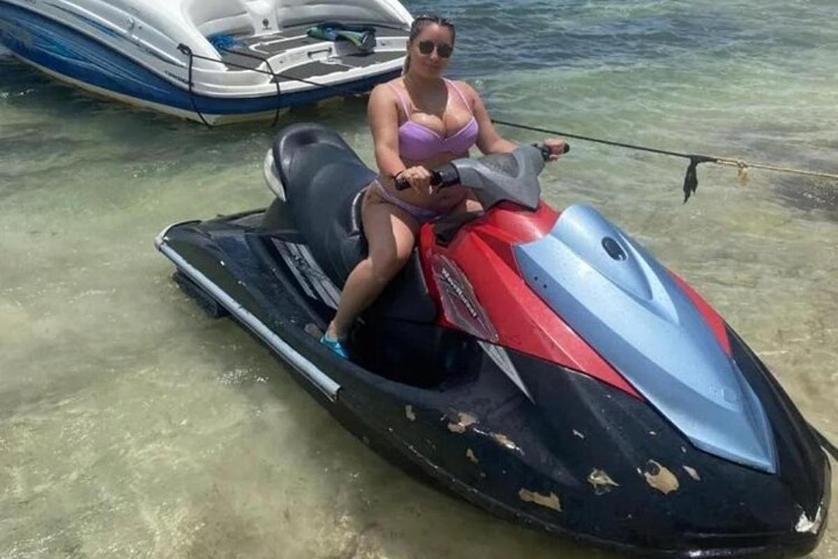 žena v bikinách sedící na vodním skútru ve vodě