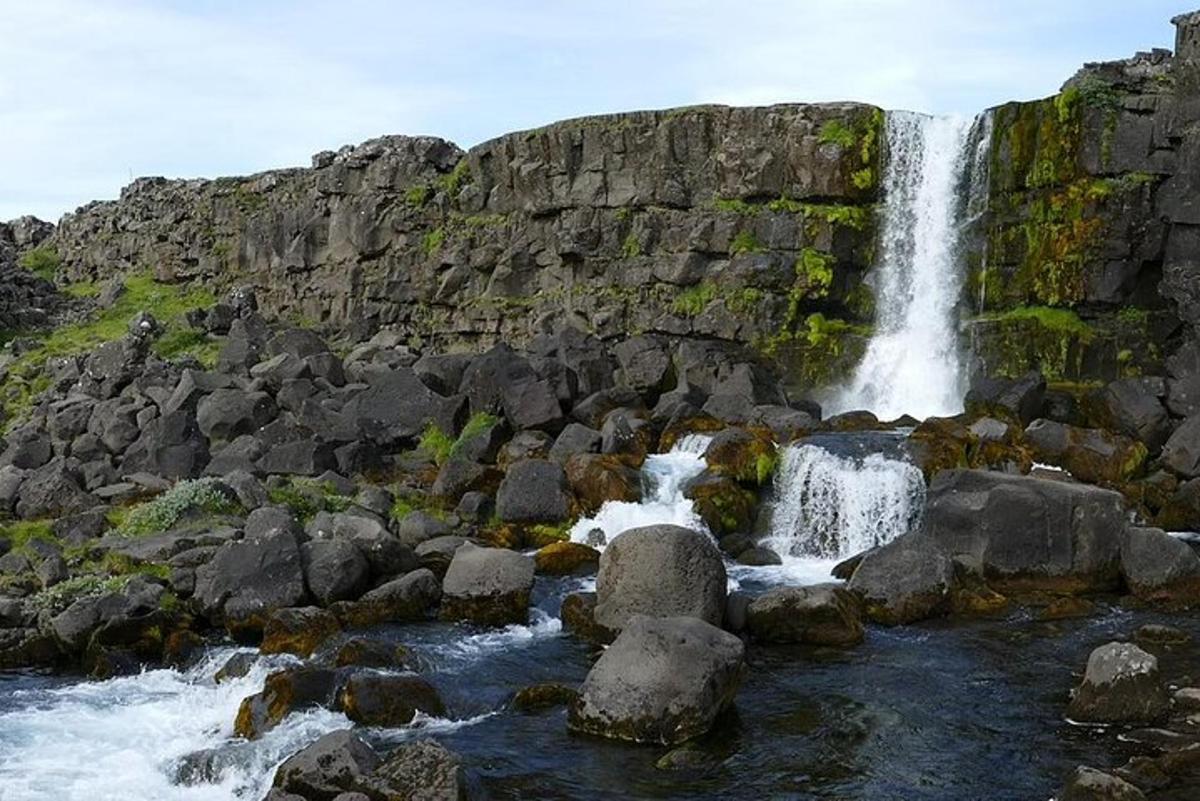 ein Wasserfall an der Seite eines felsigen Berges