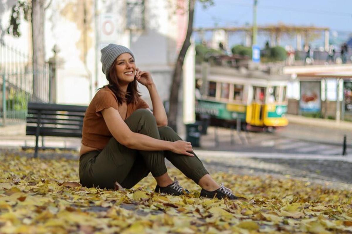 žena sedící v listí a telefonující