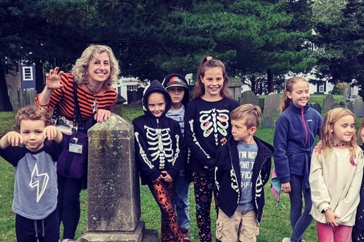 eine Gruppe von Kindern steht neben einem Friedhof