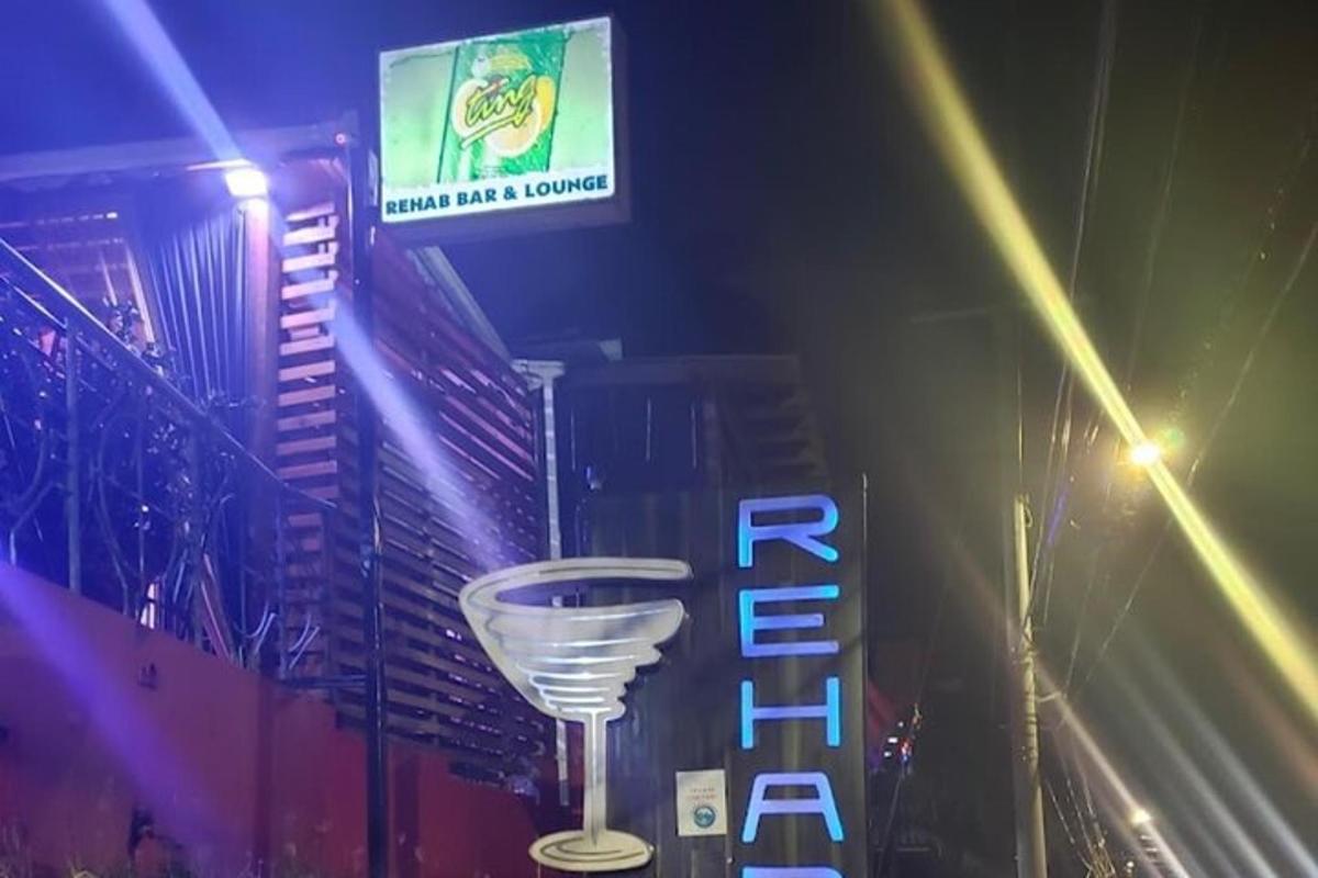 Un cartel de un bar con una copa de vino.