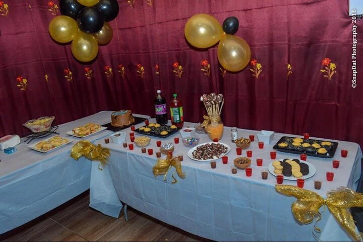 Una mesa con comida y globos encima.