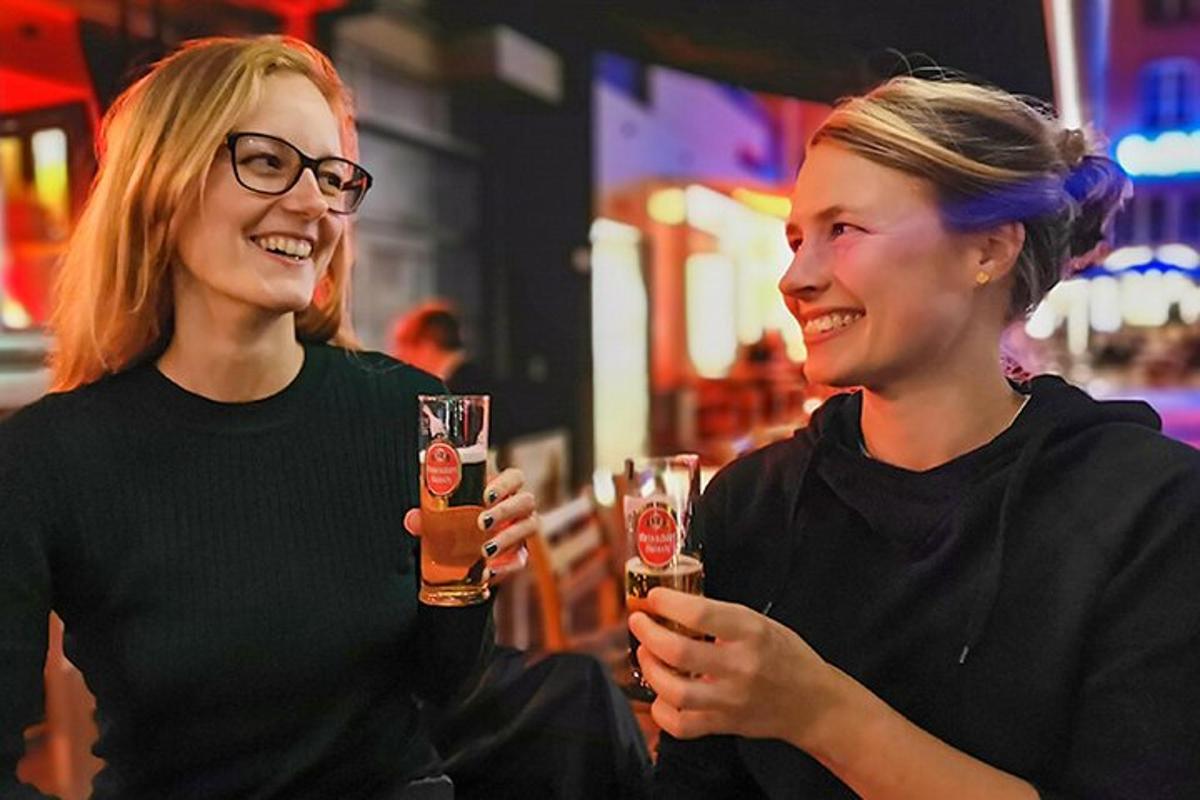 Két nő mosolyog, miközben sört tart a kezében