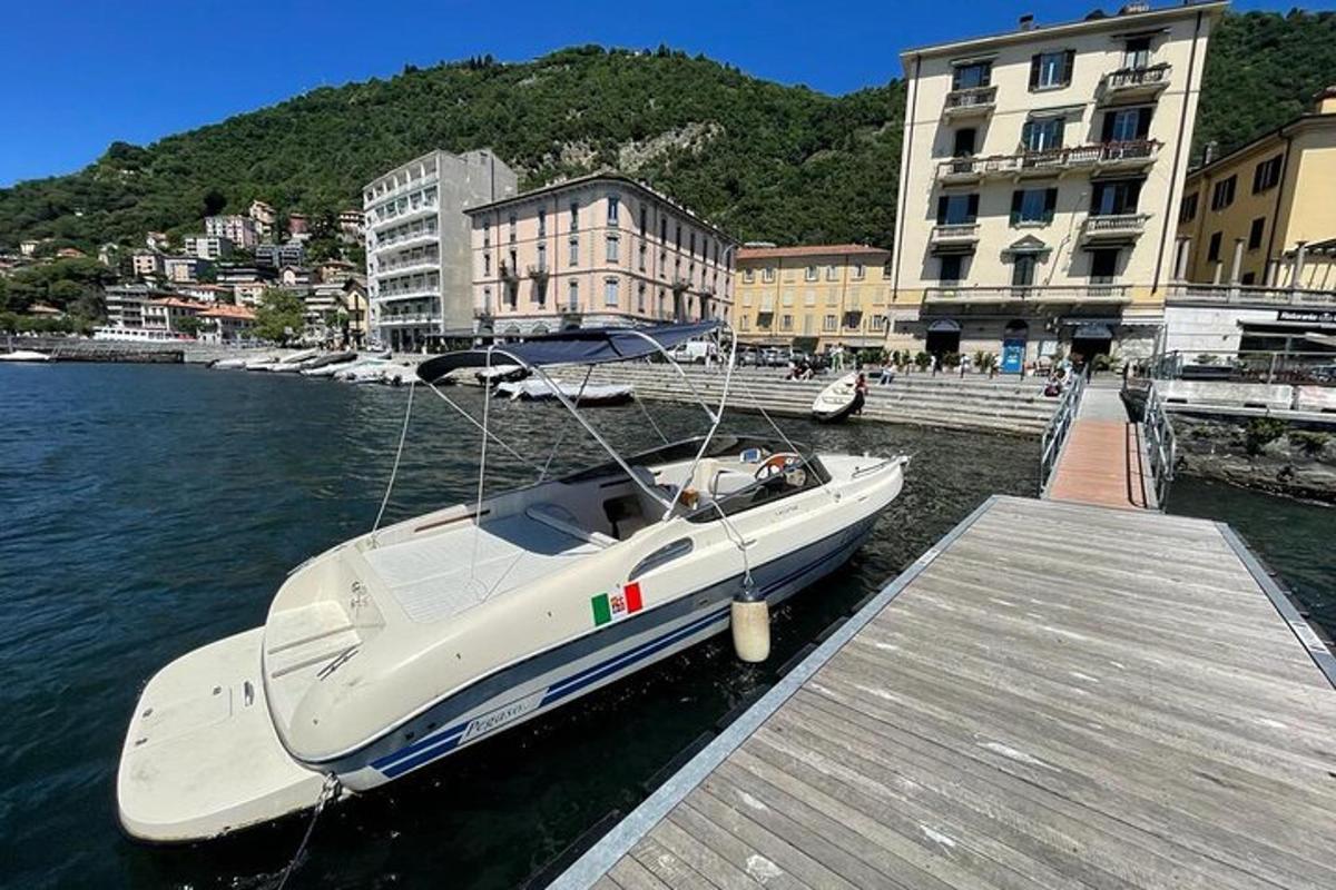 a white boat is docked at a dock
