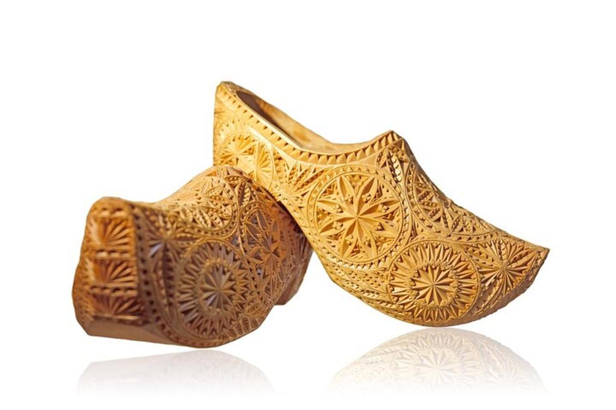 Un par de zapatos dorados sobre un fondo blanco.