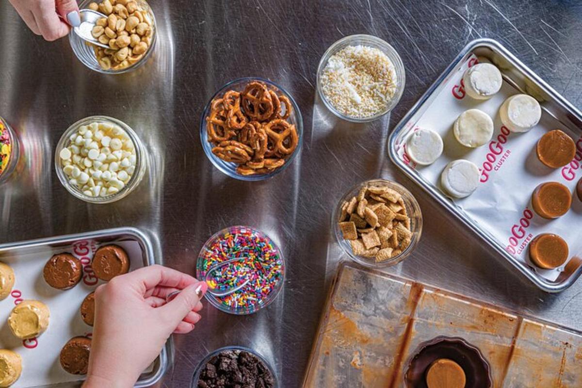a person eating a doughnut with sprinkles on a table