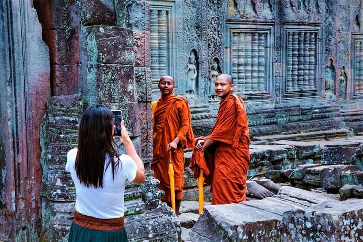một người phụ nữ đang chụp ảnh hai nhà sư trong một ngôi chùa