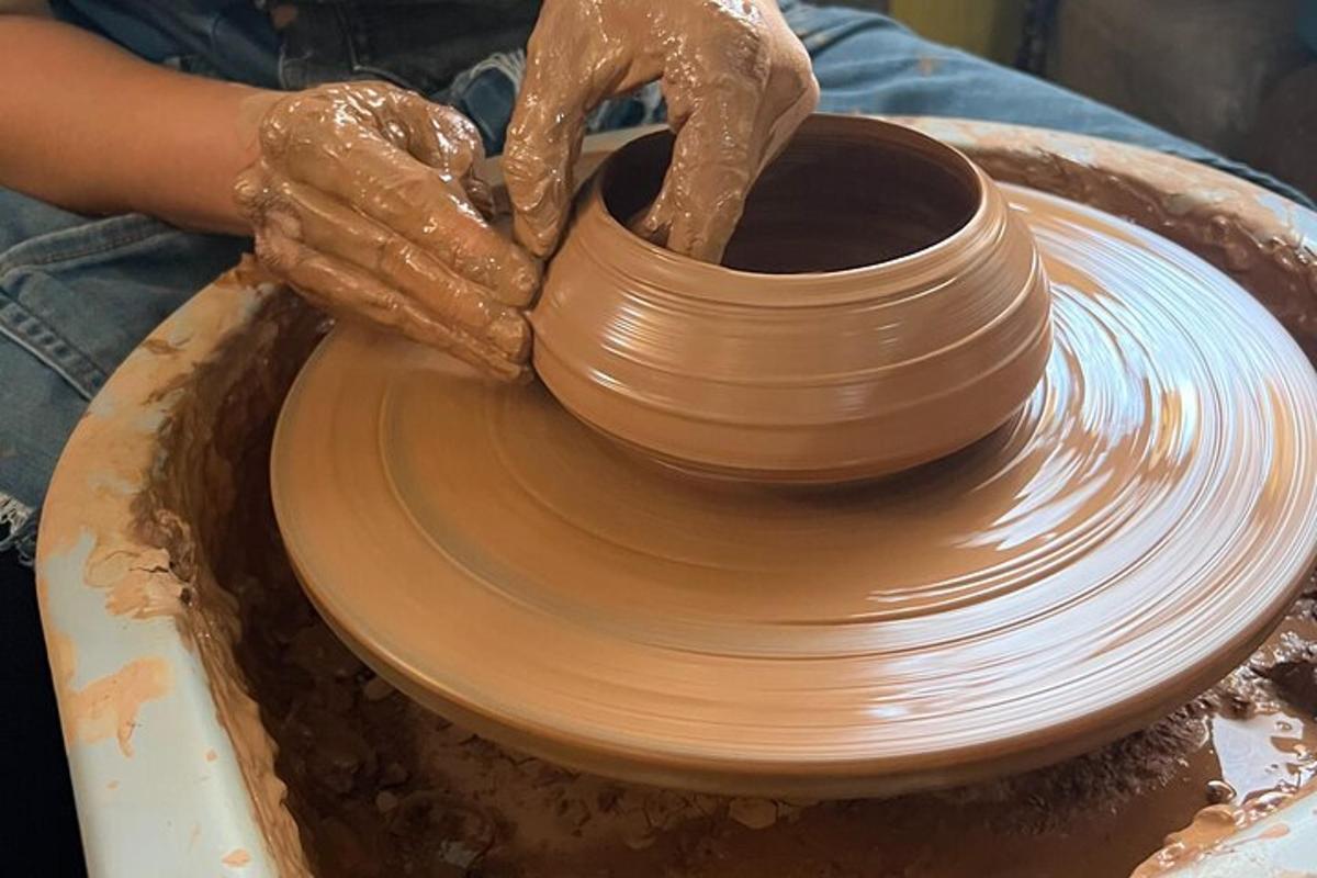 a person making a pot on a pottery wheel