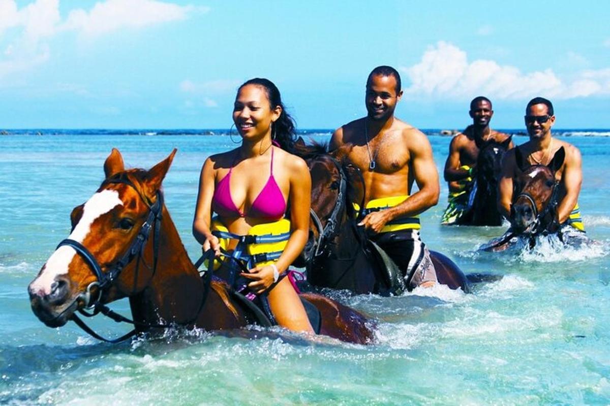um grupo de pessoas andando a cavalo no oceano