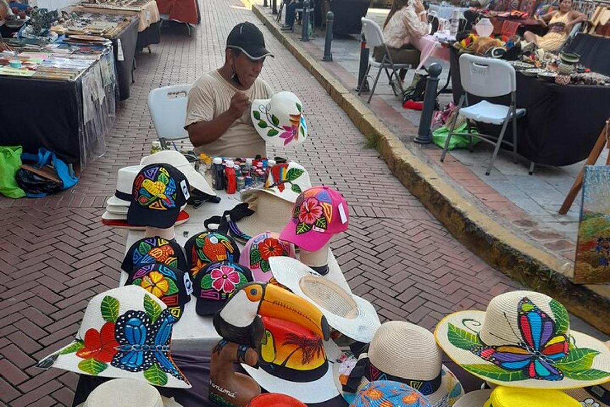 un uomo seduto a un tavolo con dei cappelli sopra