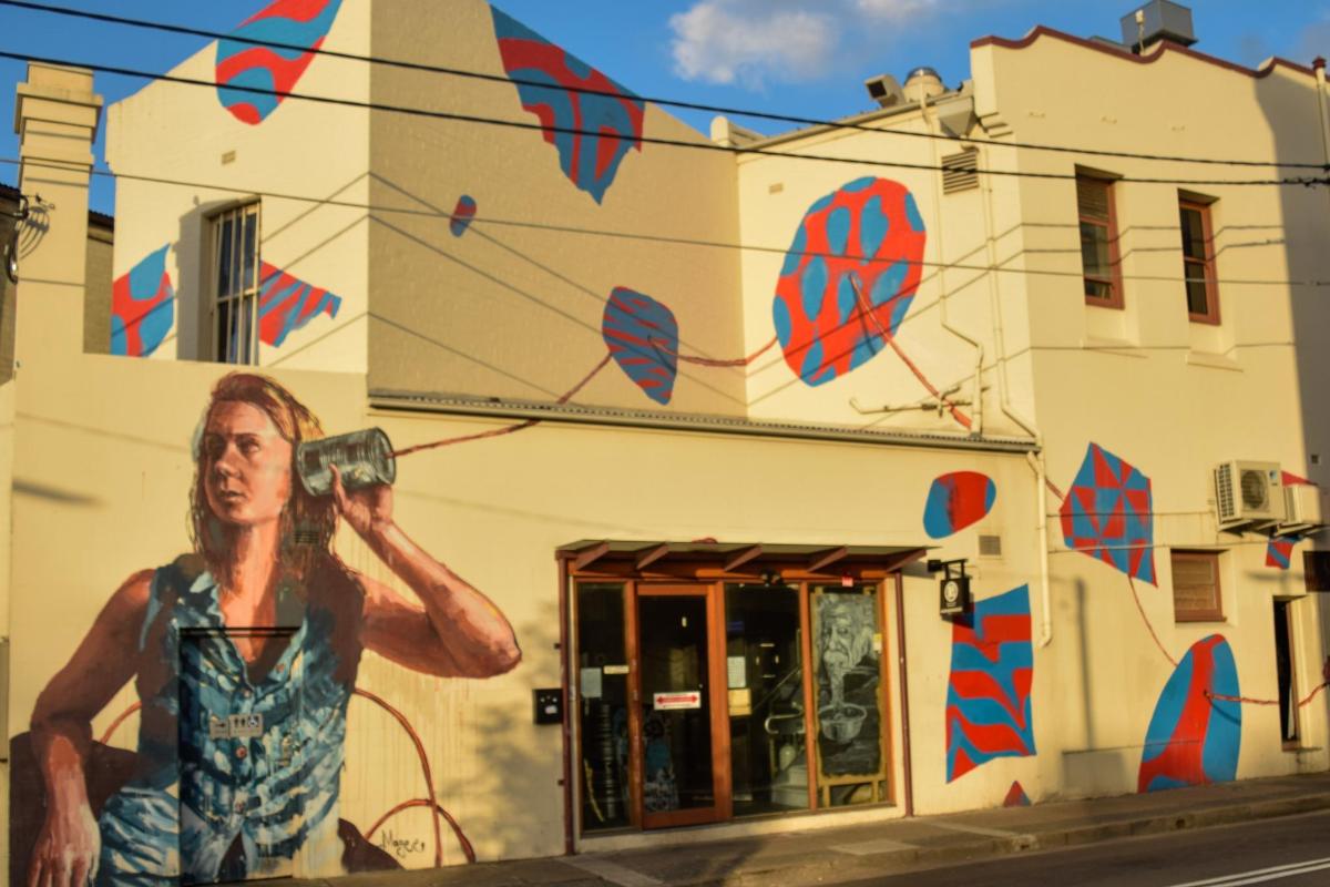 a painting of a man with a camera on the side of a building