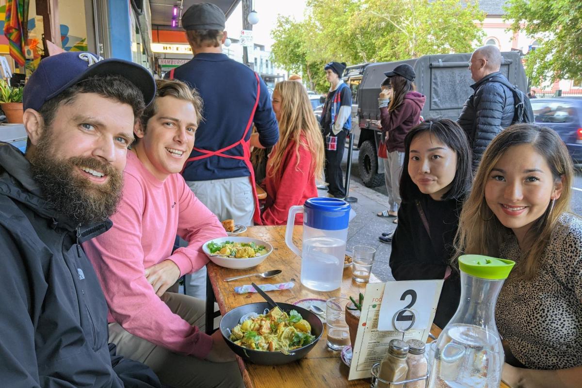 a group of people sitting at a table with food