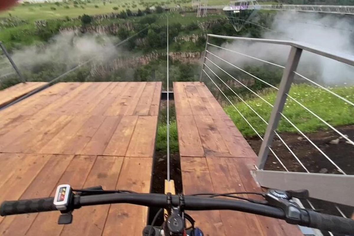 o persoană care merge cu bicicleta pe o terasă de lemn