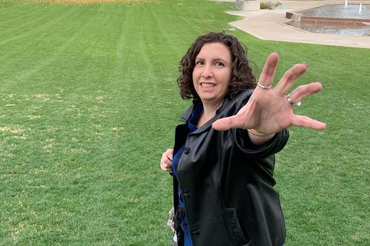 eine Frau, die mit erhobener Hand auf einem Feld steht