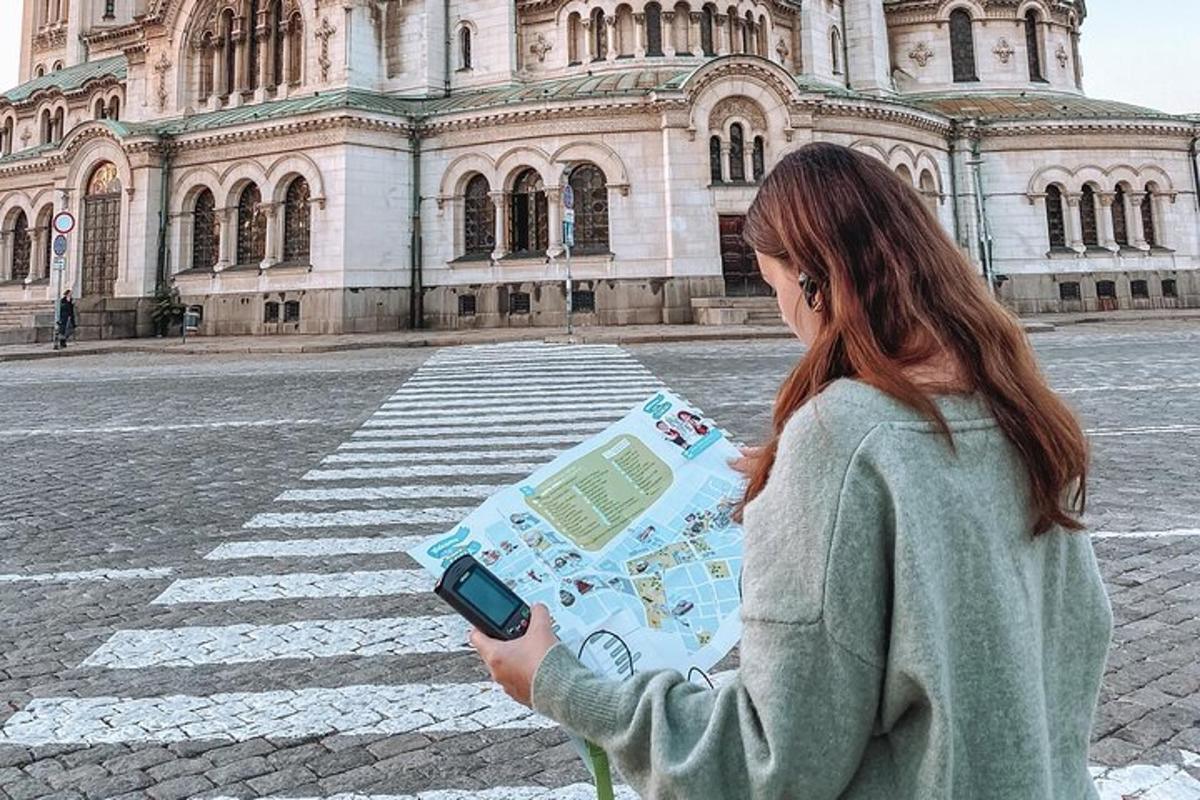 a woman holding a map in front of a building
