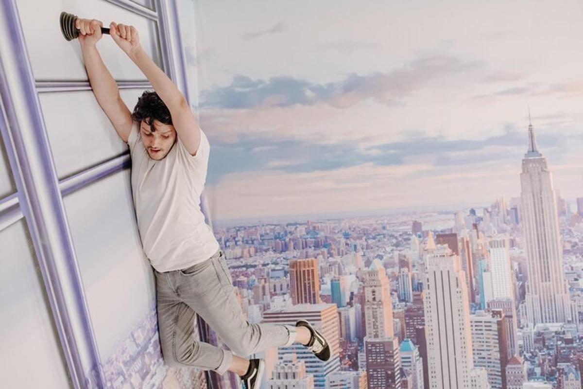 a man hanging from a window in a skyscraper