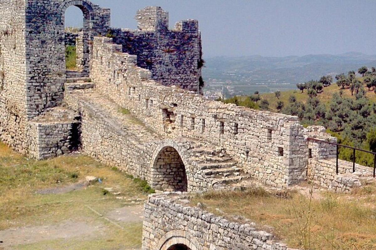 un vecchio muro di pietra con un castello sullo sfondo