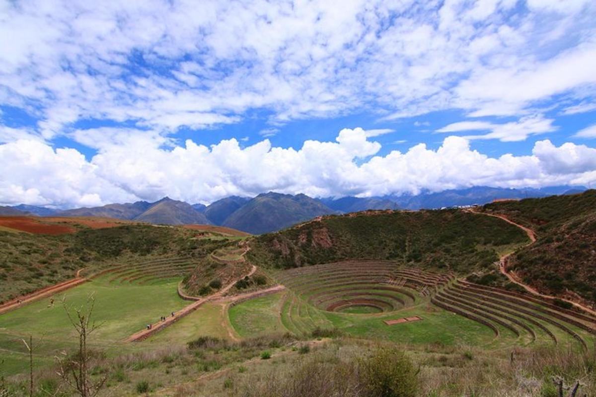 Un anfiteatro en un campo con montañas al fondo.