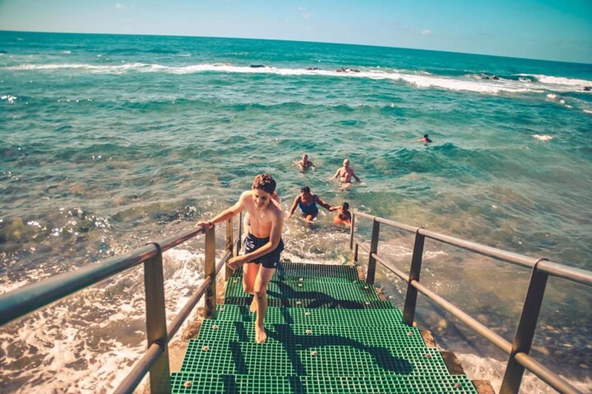eine Frau, die die Treppe zum Strand hinuntergeht