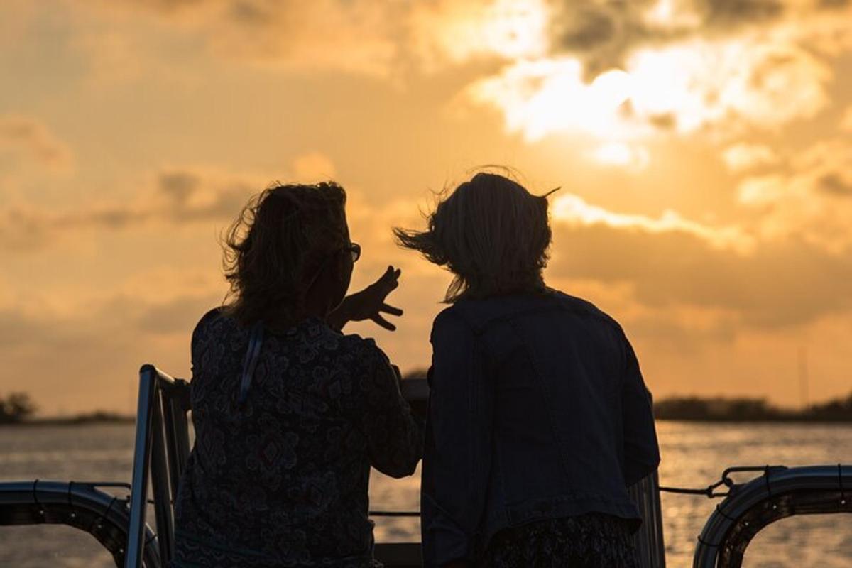 two women sitting on a boat watching the sunset