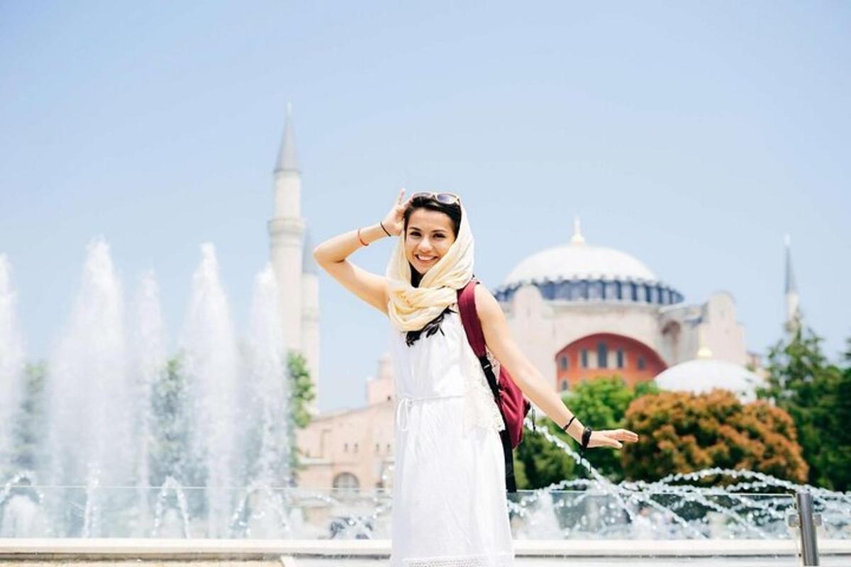 una dona amb un vestit blanc davant d'una font