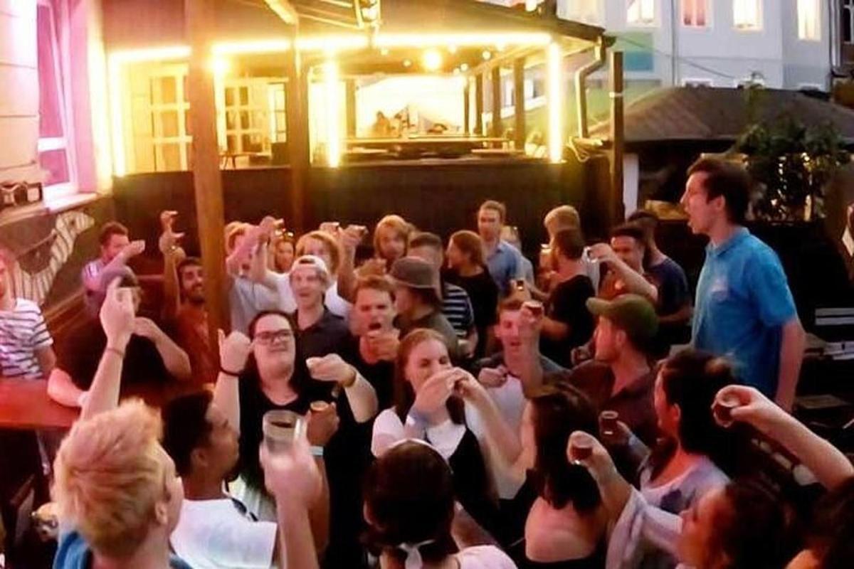 en stor gruppe mennesker som holder hendene i været