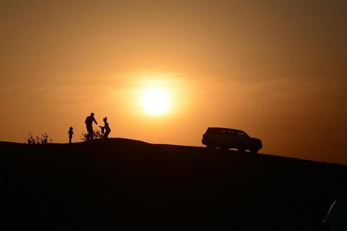 two people and a van on a hill at sunset