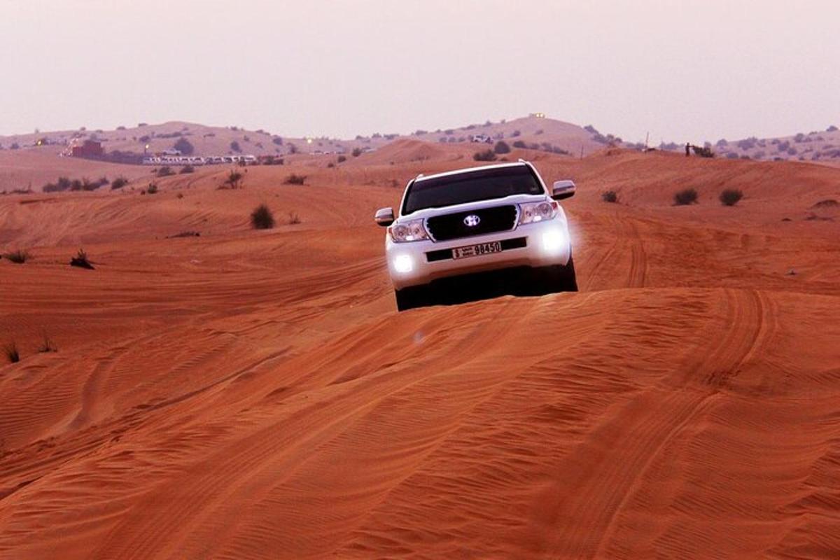 a truck driving on a dirt road in the desert
