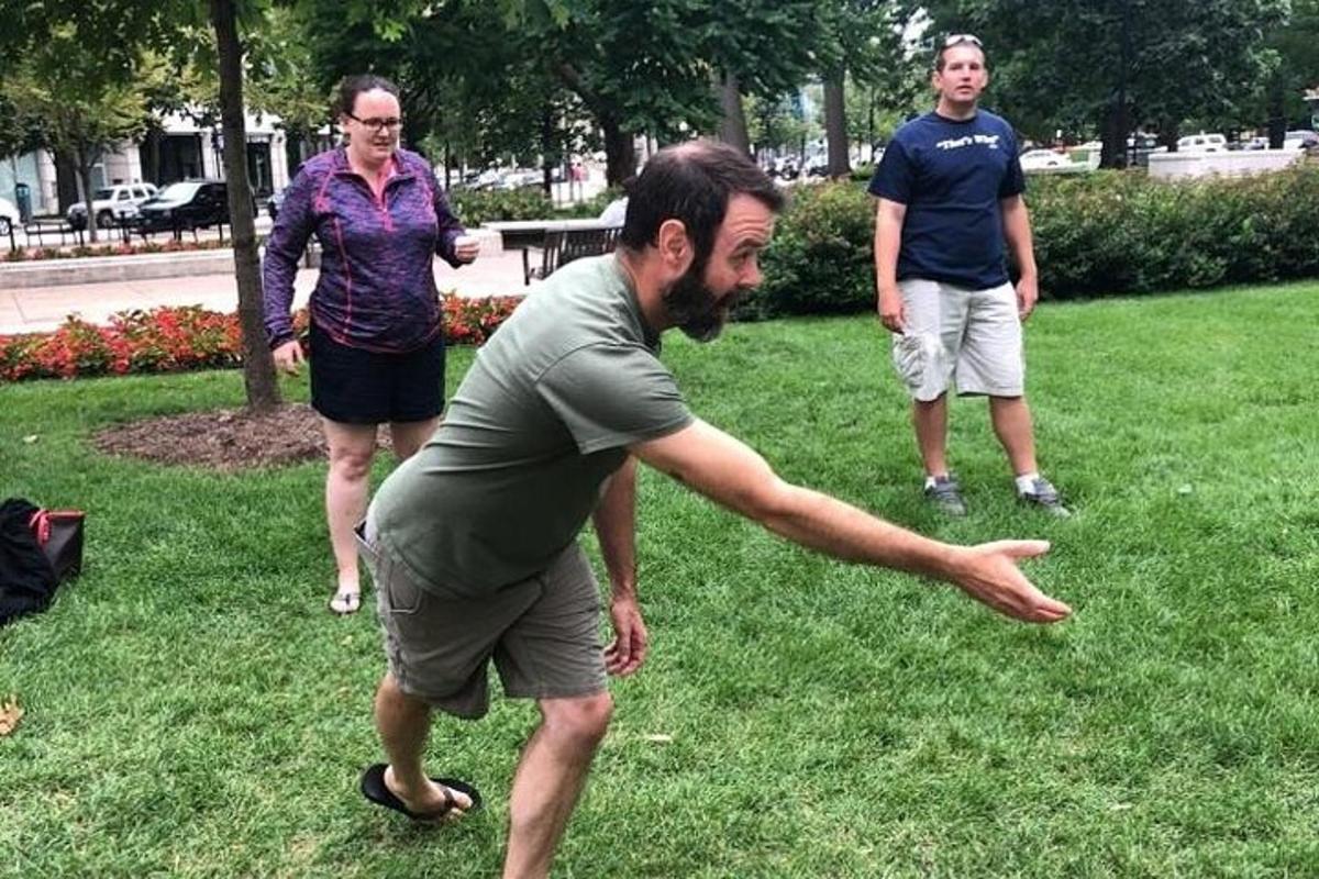 Dos hombres y una mujer jugando al frisbee en un parque