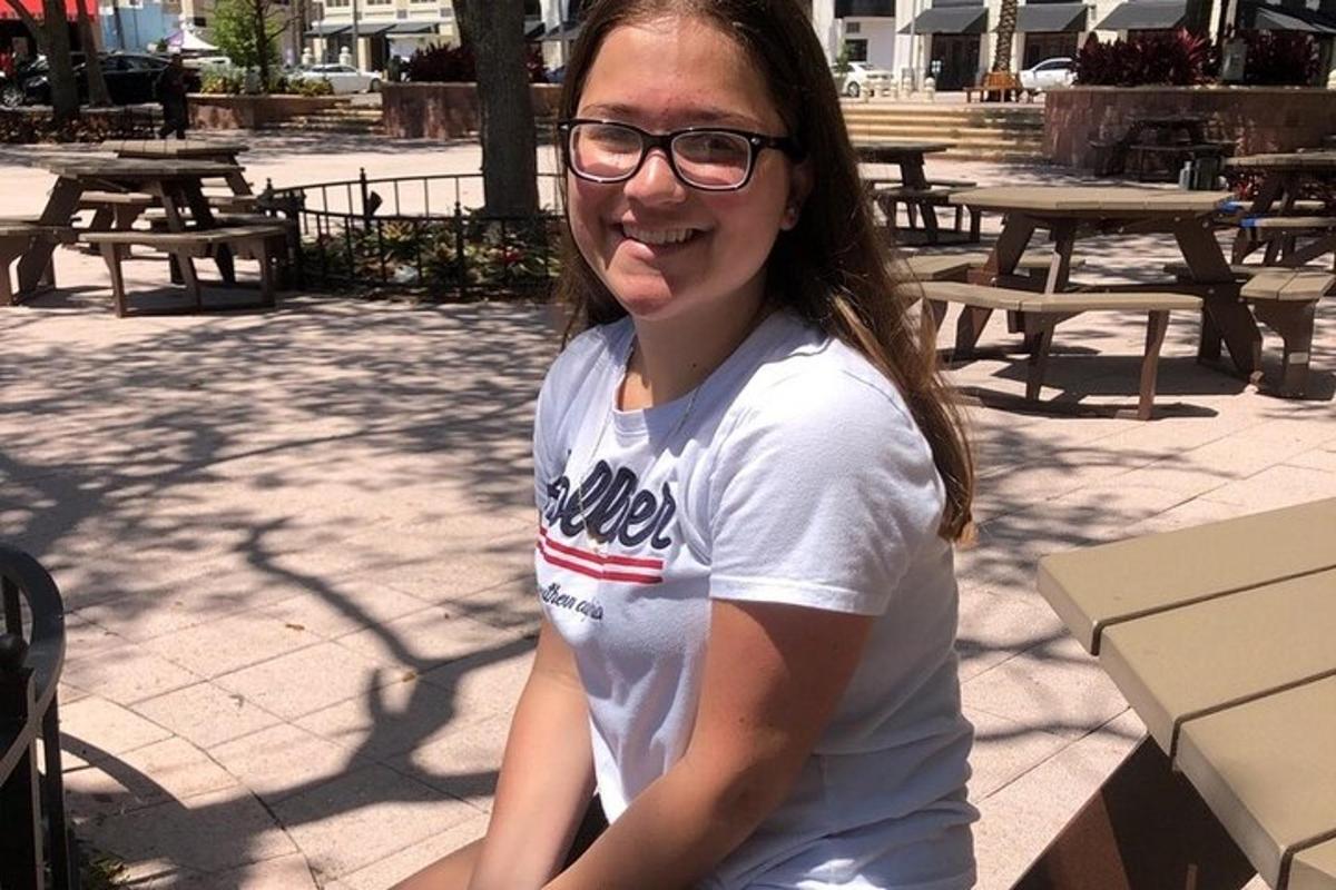 Una mujer joven con gafas sentada en un banco
