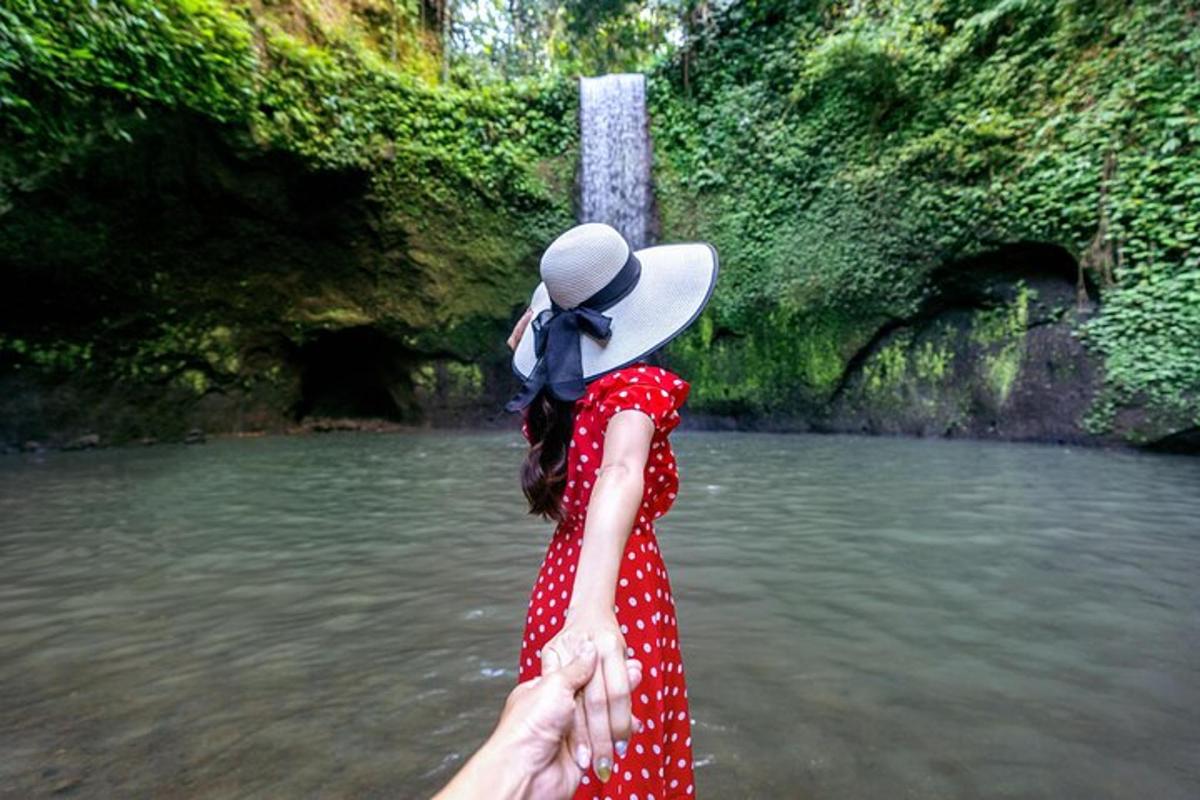 seorang wanita berpakaian merah berdiri di sungai