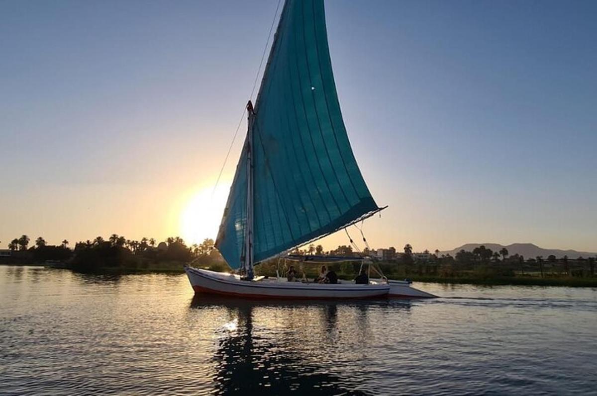 a boat with a green sail on the water