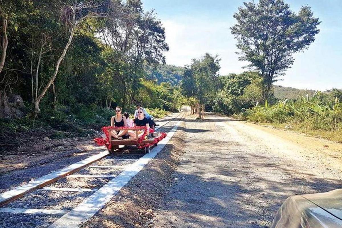 two women riding on a red wagon down a dirt road