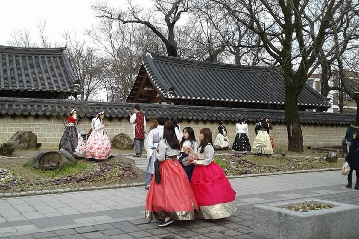 Un grupo de personas vestidas con trajes tradicionales de pie frente a un edificio.